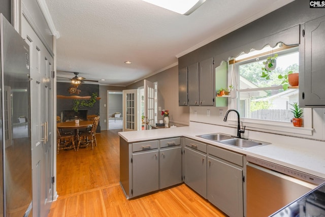 1302 Sunnyhill Dr, Camden, SC 29020 - kitchen with a sink, a peninsula, stainless steel appliances, light wood-style floors, and a ceiling fan