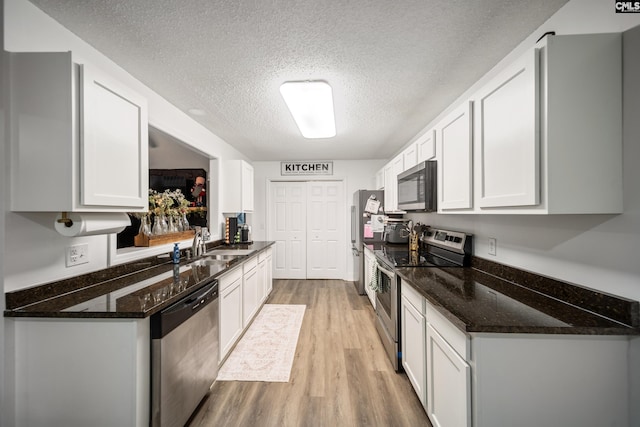 173 Snow Ln, Lexington, SC 29073 - kitchen with appliances with stainless steel finishes, light wood finished floors, a textured ceiling, white cabinets, and a sink