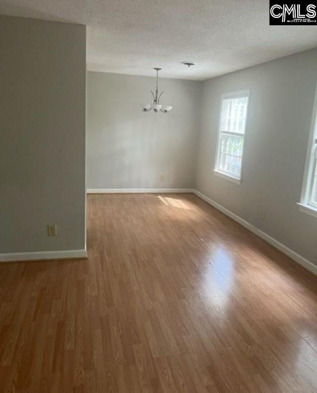 264 Piney Grove Rd, Columbia, SC 29210 - unfurnished room with a chandelier, wood finished floors, baseboards, and a textured ceiling