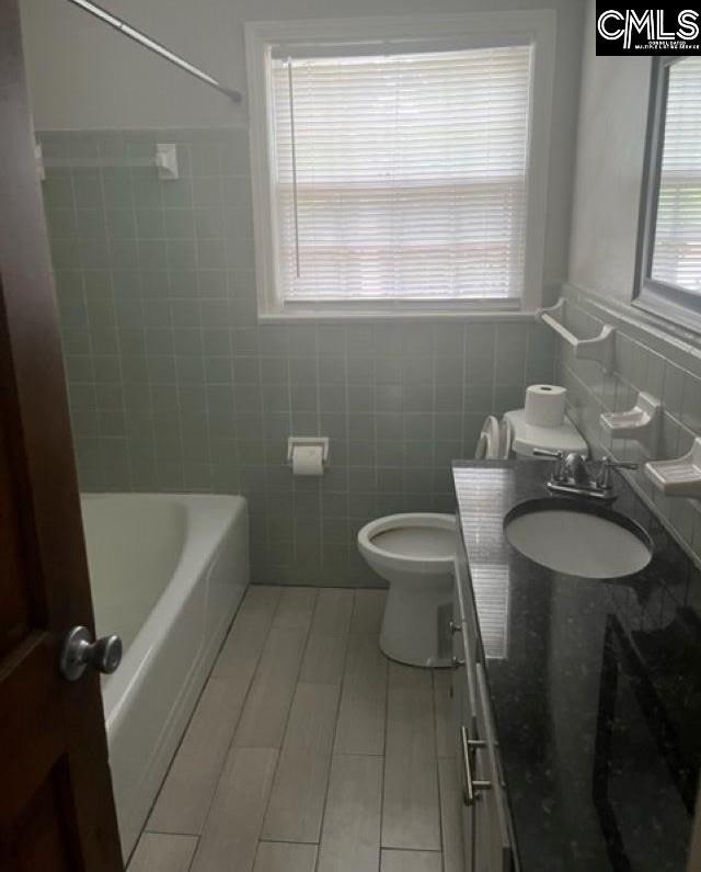 264 Piney Grove Rd, Columbia, SC 29210 - full bath with tile walls, vanity, plenty of natural light, toilet, and shower / washtub combination
