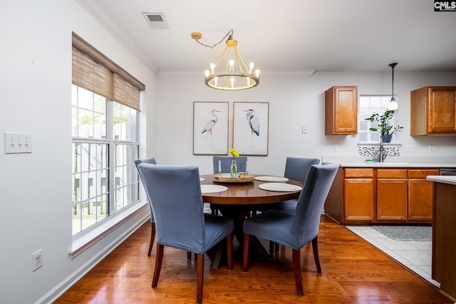 307 Swallowtail Ln, West Columbia, SC 29169 - dining area with a chandelier, crown molding, and light wood finished floors
