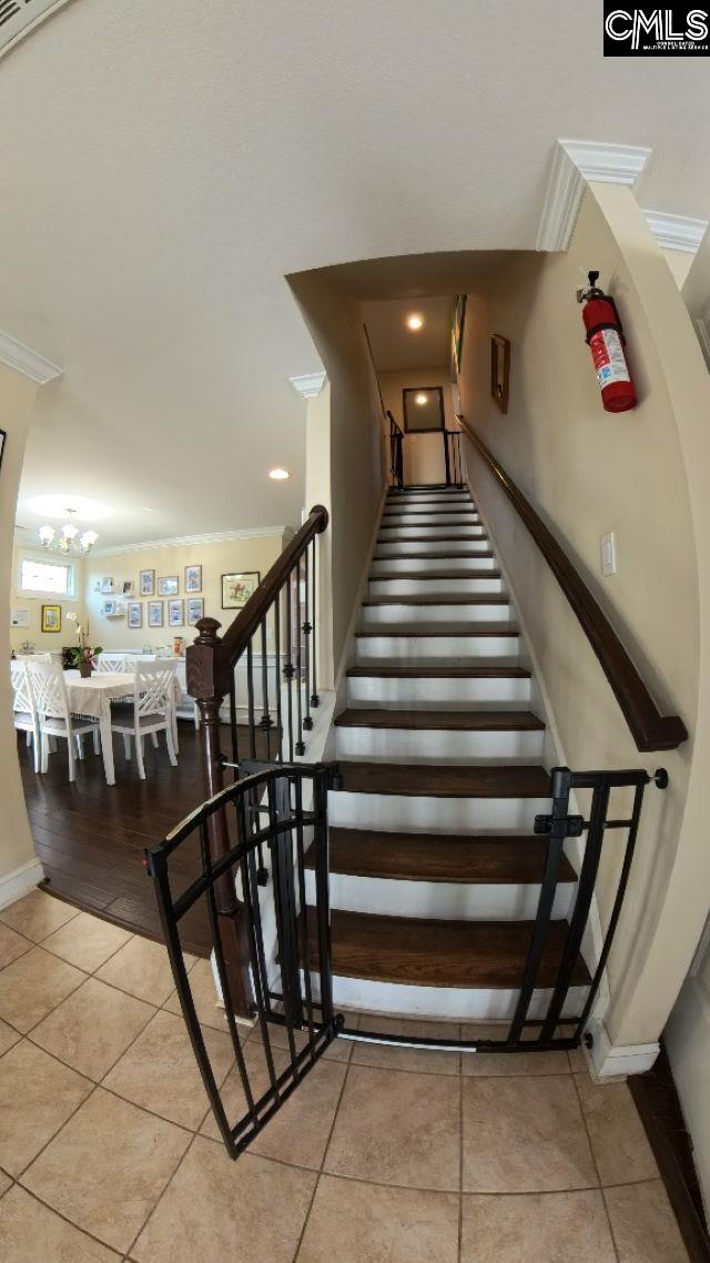1 Twinspur Ct, Columbia, SC 29229 - stairway with ornamental molding, tile patterned floors, baseboards, a chandelier, and recessed lighting
