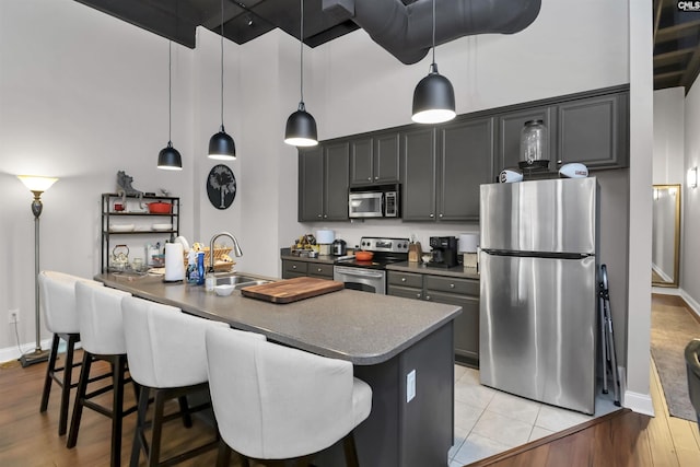 1049 Key Rd Unit 22, Columbia, SC 29201 - kitchen with appliances with stainless steel finishes, a sink, dark countertops, a breakfast bar, and a high ceiling