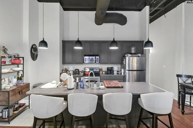 1049 Key Rd Unit 22, Columbia, SC 29201 - kitchen with stainless steel appliances, a sink, a breakfast bar area, an island with sink, and a high ceiling