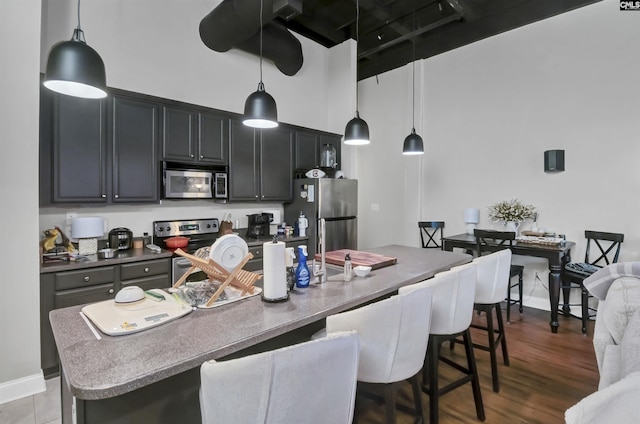 1049 Key Rd Unit 22, Columbia, SC 29201 - kitchen with stainless steel appliances, a breakfast bar, a towering ceiling, a center island with sink, and pendant lighting