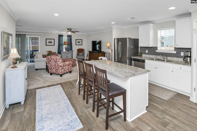 206 Carriagebrook Cir, Camden, SC 29020 - kitchen featuring appliances with stainless steel finishes, ceiling fan, a sink, a breakfast bar, and a center island