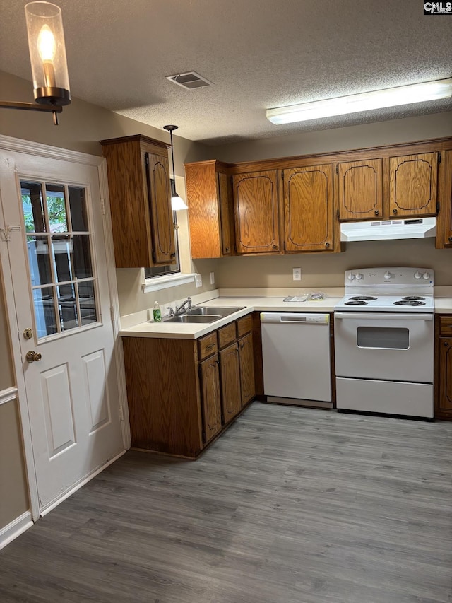 6 Bradley Ct Unit B, Cayce, SC 29033 - kitchen with white appliances, under cabinet range hood, a sink, brown cabinetry, and a textured ceiling
