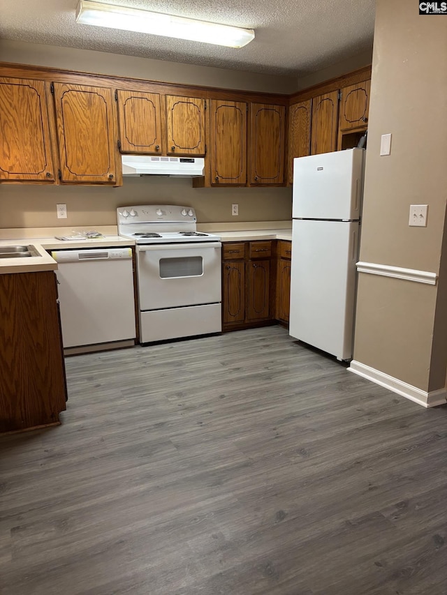 6 Bradley Ct Unit B, Cayce, SC 29033 - kitchen with white appliances, under cabinet range hood, brown cabinetry, wood finished floors, and light countertops