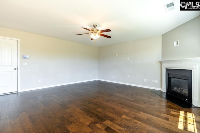 1811 Wildwood Ln, Elgin, SC 29045 - unfurnished living room featuring a ceiling fan, dark wood-style flooring, a glass covered fireplace, and baseboards
