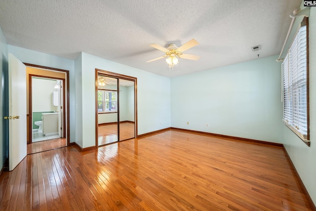 108 Commonwealth Ct, Lexington, SC 29073 - unfurnished bedroom featuring hardwood / wood-style flooring, a closet, baseboards, a textured ceiling, and a ceiling fan