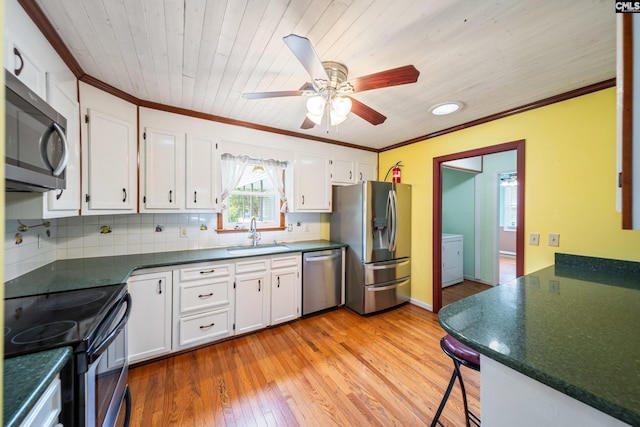 108 Commonwealth Ct, Lexington, SC 29073 - kitchen with appliances with stainless steel finishes, a sink, dark countertops, white cabinetry, and crown molding