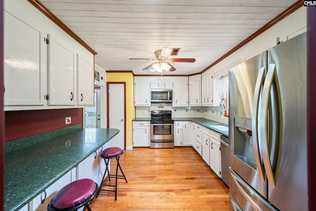 108 Commonwealth Ct, Lexington, SC 29073 - kitchen featuring stainless steel appliances, dark countertops, light wood-type flooring, decorative backsplash, and white cabinets