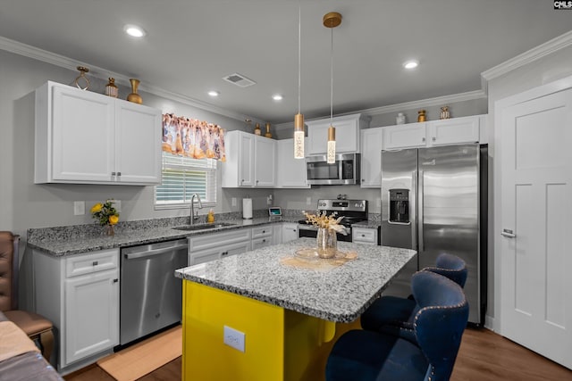 1020 Cameron Ridge Dr, Columbia, SC 29209 - kitchen with appliances with stainless steel finishes, a sink, crown molding, white cabinets, and a center island