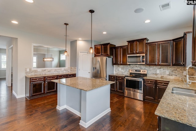 145 Decoy Ct, Sumter, SC 29145 - kitchen with appliances with stainless steel finishes, a sink, backsplash, dark brown cabinets, and light stone counters