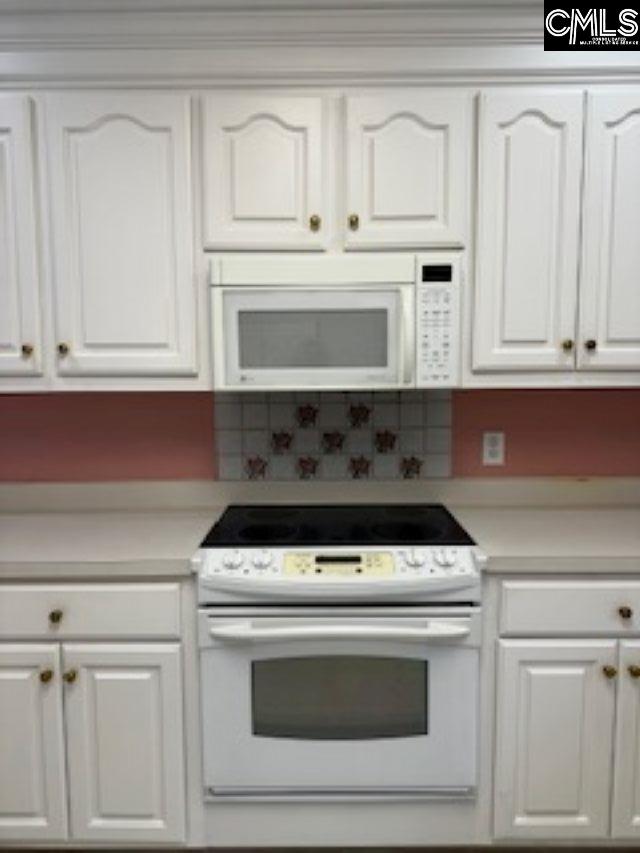117 York Commons, Lexington, SC 29072 - kitchen featuring white appliances, white cabinets, light countertops, decorative backsplash, and ornamental molding