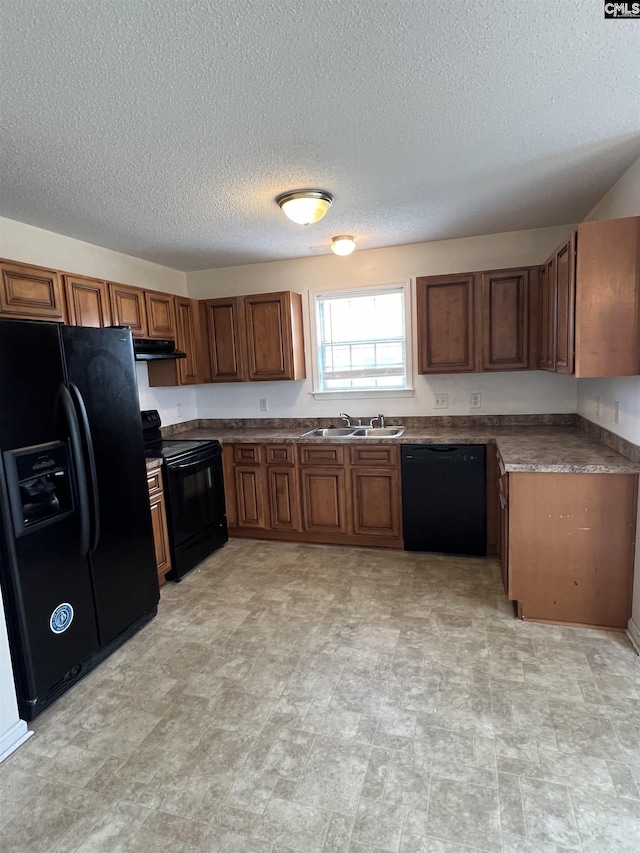 100 Battery Creek Dr, Gaston, SC 29053 - kitchen featuring black appliances, under cabinet range hood, brown cabinets, a sink, and a textured ceiling