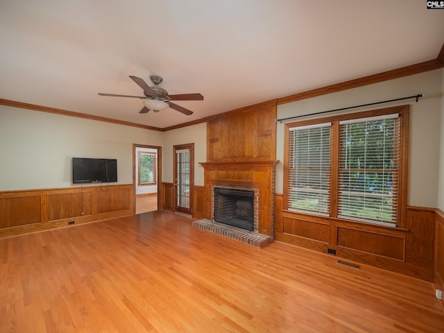 117 Falmouth Rise Rd, Columbia, SC 29229 - unfurnished living room with light wood-style flooring, ceiling fan, a brick fireplace, ornamental molding, and wainscoting