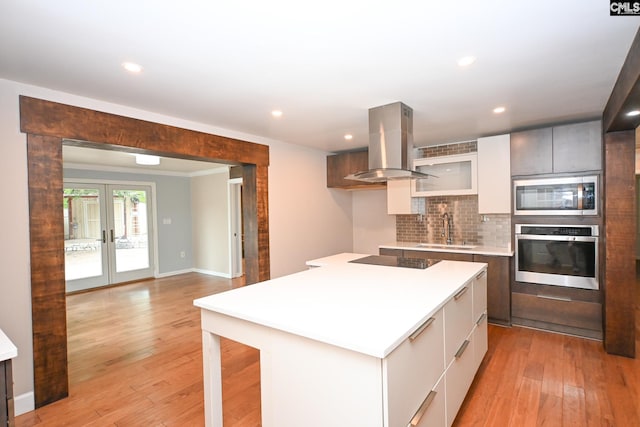 2110 Bouknight St, Newberry, SC 29108 - kitchen featuring appliances with stainless steel finishes, island range hood, a sink, modern cabinets, and decorative backsplash