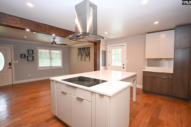 2110 Bouknight St, Newberry, SC 29108 - kitchen with island range hood, black electric stovetop, a center island, baseboards, and light countertops