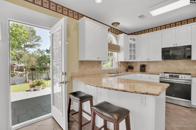 175 Stoney Pointe Dr, Chapin, SC 29036 - kitchen with black microwave, stainless steel electric range oven, a sink, light stone countertops, and glass insert cabinets