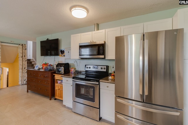 1921 Cunningham Rd, Columbia, SC 29210 - kitchen with appliances with stainless steel finishes, white cabinets, dark countertops, and a textured ceiling