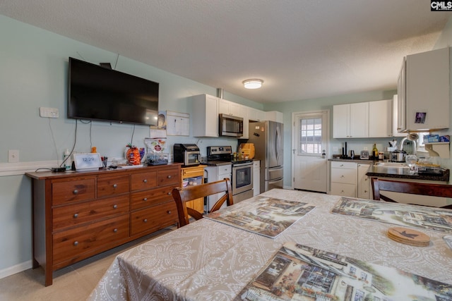 1921 Cunningham Rd, Columbia, SC 29210 - kitchen featuring stainless steel appliances, dark countertops, and white cabinetry