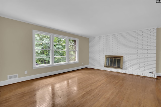 1669 Upland Dr, Columbia, SC 29204 - unfurnished living room with wood finished floors, baseboards, a fireplace, and brick wall