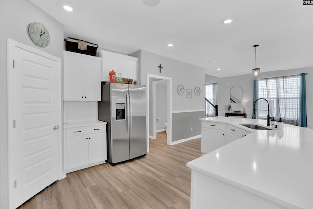 1051 Ashcroft Cir, Columbia, SC 29229 - kitchen with stainless steel fridge, a sink, light wood finished floors, white cabinets, and recessed lighting