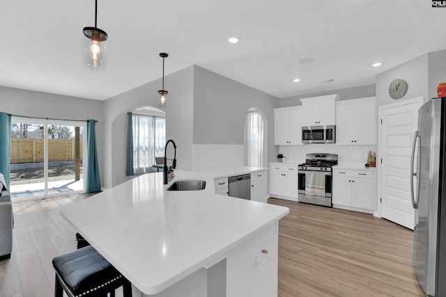 1051 Ashcroft Cir, Columbia, SC 29229 - kitchen with stainless steel appliances, a sink, arched walkways, light wood finished floors, and light countertops