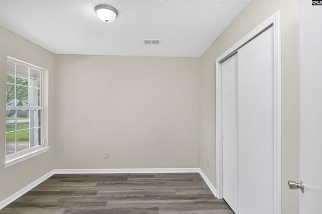 414 Fountain Lk, Columbia, SC 29209 - unfurnished bedroom with dark wood-type flooring, a textured ceiling, a closet, and baseboards