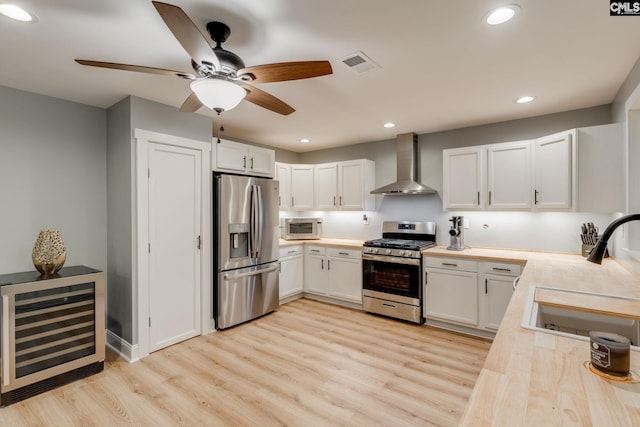 3308 Keenan Dr, Columbia, SC 29201 - kitchen featuring stainless steel appliances, wall chimney range hood, beverage cooler, a sink, and light wood-type flooring