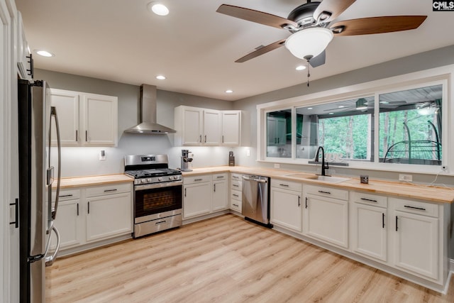 3308 Keenan Dr, Columbia, SC 29201 - kitchen featuring wall chimney range hood, appliances with stainless steel finishes, a sink, wood counters, and recessed lighting
