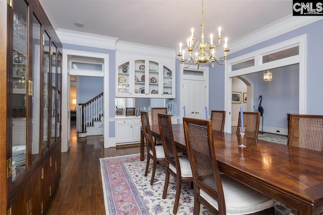 7021 Cleaton Rd, Columbia, SC 29206 - dining area with a chandelier, arched walkways, ornamental molding, dark wood-type flooring, and stairs