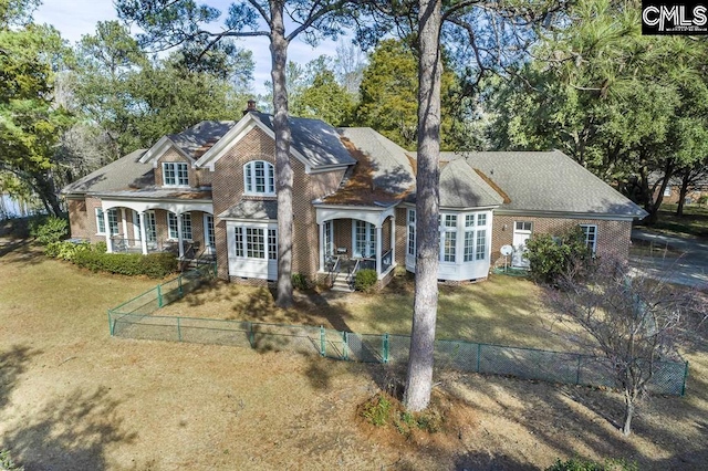 7021 Cleaton Rd, Columbia, SC 29206 - view of front of house featuring a porch, a chimney, view of scattered trees, and brick siding
