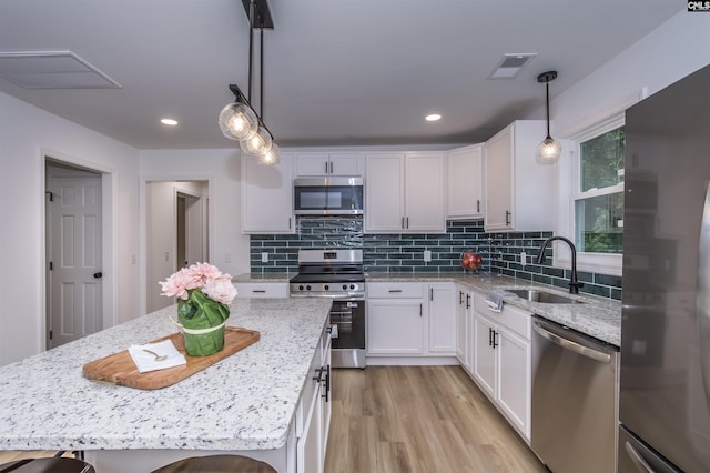 108 Bickleigh Rd, Irmo, SC 29063 - kitchen with appliances with stainless steel finishes, a sink, white cabinets, light stone countertops, and light wood-type flooring