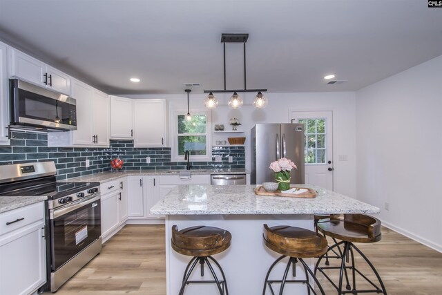108 Bickleigh Rd, Irmo, SC 29063 - kitchen with appliances with stainless steel finishes, a breakfast bar area, white cabinets, backsplash, and recessed lighting