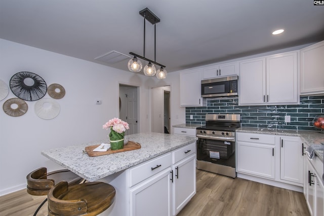 108 Bickleigh Rd, Irmo, SC 29063 - kitchen with stainless steel appliances, white cabinets, backsplash, and a kitchen breakfast bar