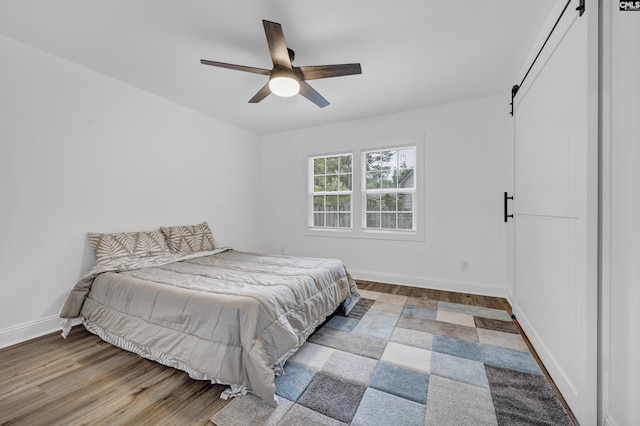 225 Park Shore Dr, Columbia, SC 29223 - bedroom with wood finished floors, a barn door, baseboards, and ceiling fan