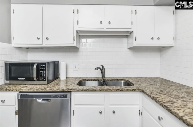 619 King St Unit 608, Columbia, SC 29205 - kitchen with appliances with stainless steel finishes, a sink, decorative backsplash, and white cabinetry