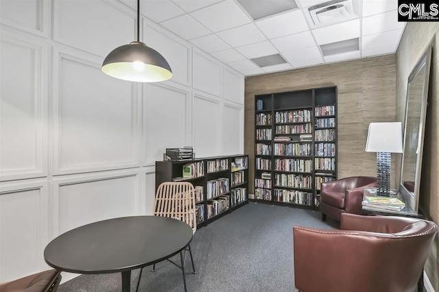 619 King St Unit 608, Columbia, SC 29205 - sitting room with a drop ceiling, a decorative wall, carpet floors, and bookshelves