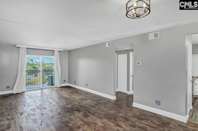 619 King St Unit 608, Columbia, SC 29205 - empty room featuring baseboards, a chandelier, and dark wood-style floors