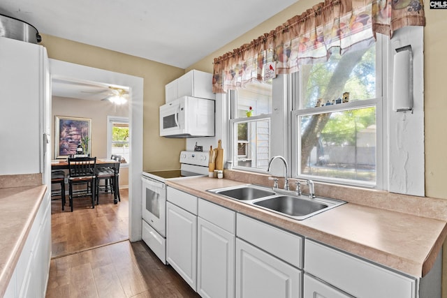 319 Graham St, West Columbia, SC 29169 - kitchen featuring white appliances, a sink, wood finished floors, and white cabinetry
