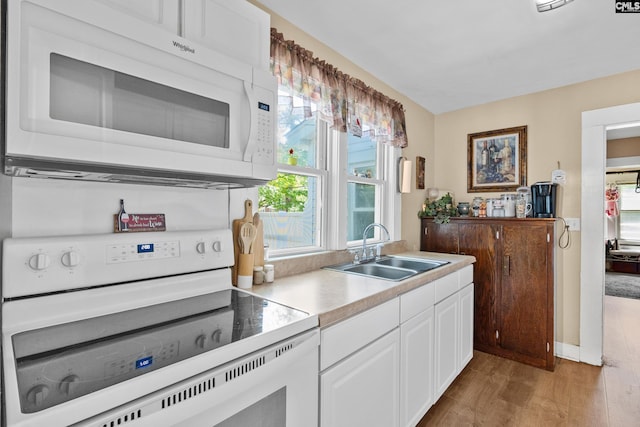 319 Graham St, West Columbia, SC 29169 - kitchen featuring white appliances, a sink, white cabinets, light wood finished floors, and light countertops