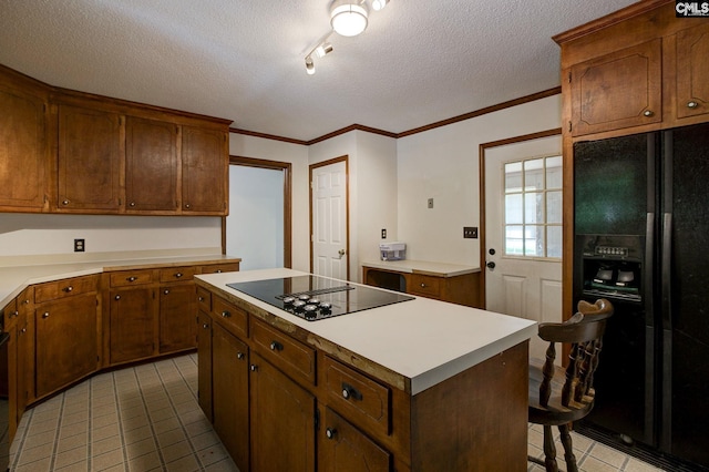 589 White Pines Cir, Camden, SC 29020 - kitchen featuring black appliances, light tile patterned floors, a textured ceiling, light countertops, and a kitchen island