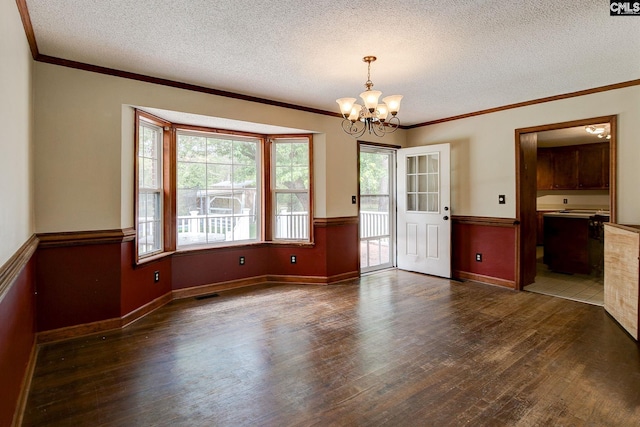 589 White Pines Cir, Camden, SC 29020 - unfurnished dining area with wood finished floors, a chandelier, ornamental molding, a textured ceiling, and wainscoting