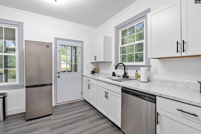 618 Joan St, Columbia, SC 29203 - kitchen with appliances with stainless steel finishes, a sink, crown molding, plenty of natural light, and light wood-style floors