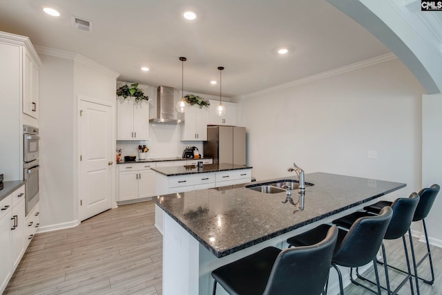 137 Brockway Dr, Columbia, SC 29229 - kitchen with an island with sink, wall chimney range hood, a sink, arched walkways, and double oven