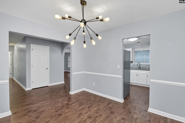 140 Otago Way W, Columbia, SC 29170 - unfurnished dining area featuring arched walkways, a chandelier, dark wood finished floors, a sink, and a textured ceiling
