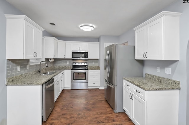 140 Otago Way W, Columbia, SC 29170 - kitchen with appliances with stainless steel finishes, a sink, dark wood-style flooring, white cabinets, and tasteful backsplash