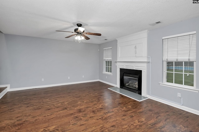 140 Otago Way W, Columbia, SC 29170 - unfurnished living room with a ceiling fan, dark wood-type flooring, a textured ceiling, a glass covered fireplace, and baseboards